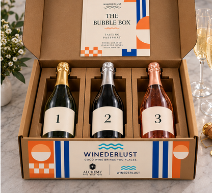 Open wine membership box with three bottles in die-cut kraft holders and tasting passport