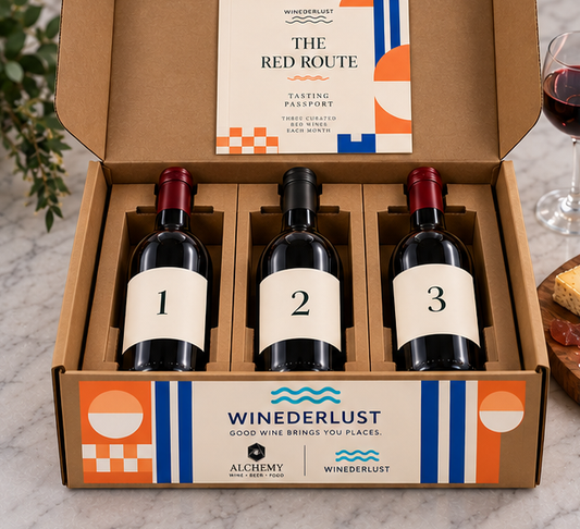 Open wine membership box with three bottles in die-cut kraft holders and tasting passport